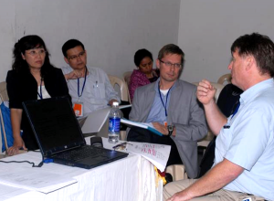 Jukka Lerkkanen ja muita konferenssin osallistujia istuu työpajatilassa 2010 Bangaloressa, Intiassa