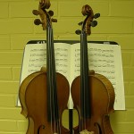 kuvassa kaksi viulua sekä nuottikirja